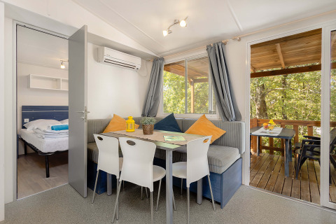Vista interior de Mobile home Capri en Camping Zelena Laguna, Croacia, con zona de comedor y terraza.