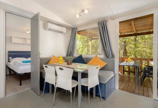Vista interna della Mobile home Capri al Camping Zelena Laguna, Croazia, con zona pranzo e terrazza.