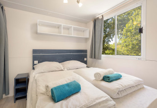 Slaapkamer in Mobile home Capri bij Camping Zelena Laguna in Kroatië, met twee bedden en grote ramen.