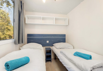 Slaapkamer in Mobile home Capri op Camping Zelena Laguna, Kroatië, met twee aparte bedden en frisse inrichting.