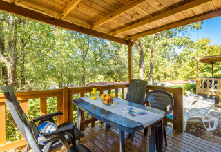 Terraza de madera cubierta con mesa, sillas y frutero en Mobile home Capri, Camping Zelena Laguna, Croacia.