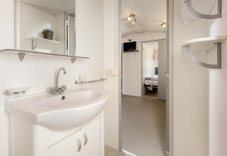 Moderne badkamer in de Capri-mobilhome op Camping Zelena Laguna, Kroatië, met wastafel en spiegel.