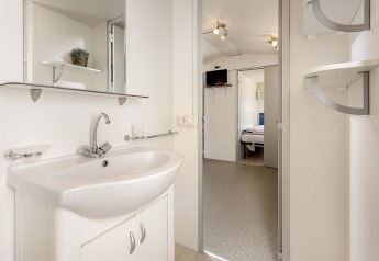 Moderne badeværelse i mobilhome Capri på Camping Zelena Laguna, Kroatien, med vask og spejl.