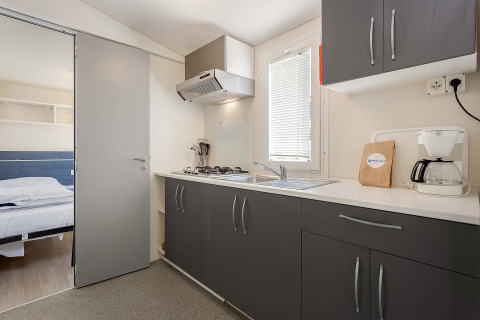 Moderne keuken in Mobile home Capri op Camping Zelena Laguna, Kroatië, met grijze kasten en koffiezetapparaat.