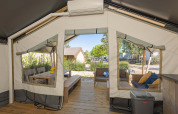 Binnenaanzicht van een Safari tent Comfort met airconditioning en een houten terras met zitgedeelte.