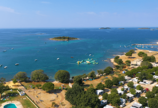 Vista aerea del Camping Polari in Istria, Croazia, con la costa adriatica, le piscine e le isole vicine.