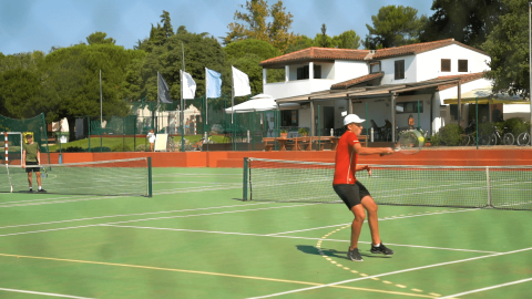 Campeggio Polari in Istria, Croazia: persone che giocano a tennis su un campo all’aperto e soleggiato.