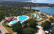 Vista dall'alto di Camping Polari in Istria, Croazia, con piscine, aree verdi e la costa vicina.