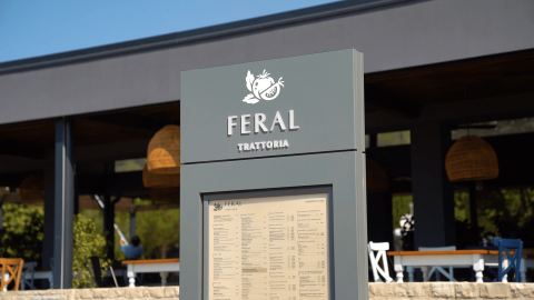 Panneau du restaurant Feral Trattoria au Camping Polari, parc de vacances en Istrie, Croatie, avec terrasse extérieure.