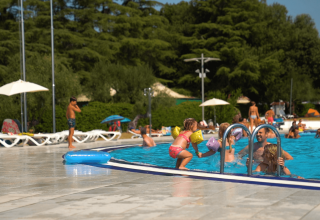Børn og familier nyder svømning og leg ved poolområdet på Camping Polari-ferieparken i Istrien, Kroatien.