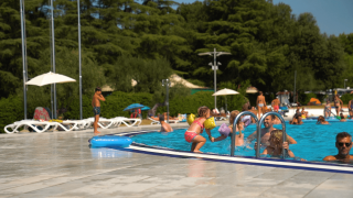 Niños y familias se divierten nadando y jugando en la piscina del camping Polari en Istria, Croacia.