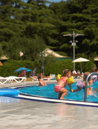 Niños y familias se divierten nadando y jugando en la piscina del camping Polari en Istria, Croacia.