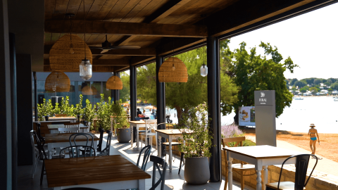 Area pranzo all'aperto al Camping Polari in Istria, Croazia, con vista sulla spiaggia e sul mare sullo sfondo.