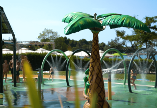 Bambini che giocano nel parco acquatico con fontana a palma al Camping Polari, parco vacanze in Istria, Croazia.