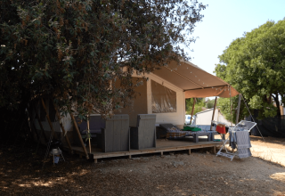Tenda glamping ombreggiata con veranda e stendibiancheria al Camping Polari, Istria, Croazia in estate.