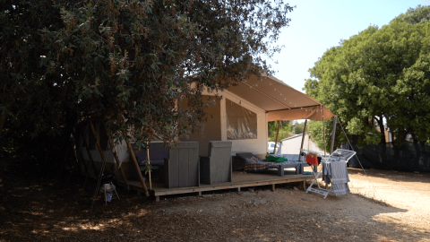 Schaduwrijke glampingtent met veranda en droogrek op Camping Polari, Istrië, Kroatië tijdens de zomer.