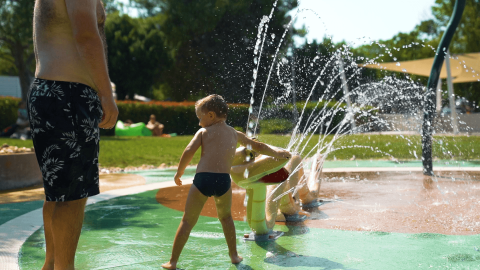 Kinder spielen an Wasserspritzern im Wasserpark des Camping Polari Ferienparks in Istrien, Kroatien.