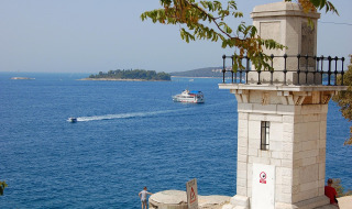 Vue sur la mer avec phare, bateaux et îles depuis un parc de vacances proposant des hébergements glamping.