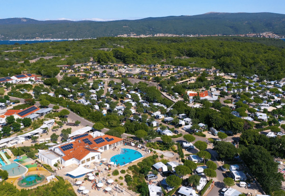 Luftfoto af Camping Krk feriepark i Primorje-Gorski Kotar, Kroatien med pools, telte og træer.