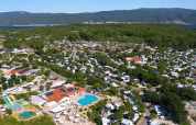 Luftfoto af Camping Krk feriepark i Primorje-Gorski Kotar, Kroatien med pools, telte og træer.