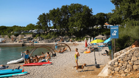 Personas descansando en una playa para perros en Camping Krk, condado de Primorje-Gorski Kotar, Croacia.