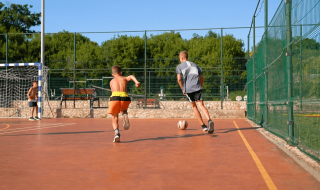 Niños juegan al fútbol en una cancha al aire libre en Camping Krk, Primorje-Gorski Kotar, Croacia.