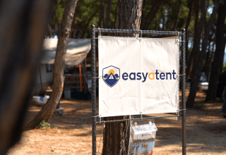 Skilt med Easyatent-logo i en skovklædt campingplads i Camping Krk, Primorje-Gorski Kotar, Kroatien.
