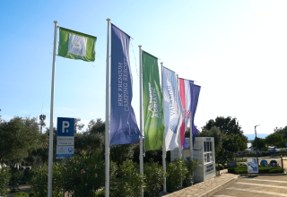 Flags at the entrance of Camping Krk holiday park in Primorje-Gorski Kotar County, Croatia, on a sunny day.