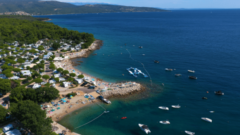 Vista aerea di Camping Krk, parco vacanze sul mare con spiaggia e barche a Primorje-Gorski Kotar, Croazia.
