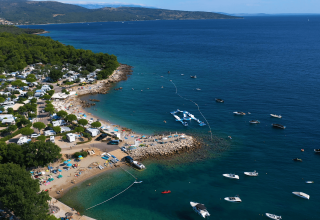 Vista aerea di Camping Krk, parco vacanze sul mare con spiaggia e barche a Primorje-Gorski Kotar, Croazia.