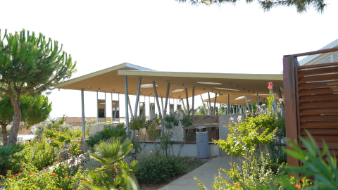 Modern paviljoen met schuin dak te midden van groene tuinen bij Camping Krk, Primorje-Gorski Kotar, Kroatië.