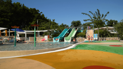 Piscina con toboganes y tumbonas en el Camping Krk, parque vacacional en Primorje-Gorski Kotar, Croacia.
