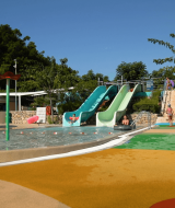 Piscina con toboganes y tumbonas en el Camping Krk, parque vacacional en Primorje-Gorski Kotar, Croacia.