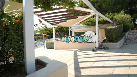 Ingang van de kinderclub bij Camping Krk, Kroatië, met een step en schaduwrijke buitenzitruimte.