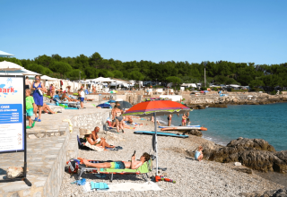 Solrige strandgæster og afslapning ved Aquapark på Camping Krk, en campingplads i Primorje-Gorski Kotar, Kroatien.