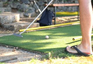 En person spiller minigolf på Camping Krk i Primorje-Gorski Kotar, Kroatien, ses i sandaler ved banen.