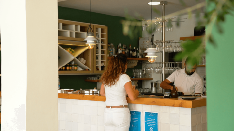 Donna al bancone moderno di un ristorante al Camping Krk, Primorje-Gorski Kotar, Croazia, di giorno.