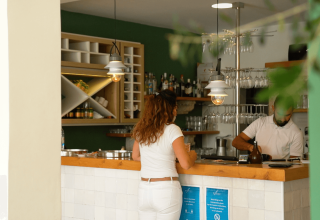 Kvinde ved moderne bardisk i restaurant på Camping Krk, Primorje-Gorski Kotar, Kroatien, dagtimer.