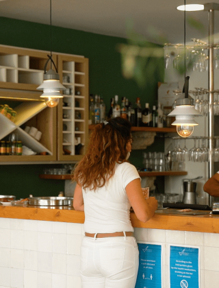Mujer en la barra de un restaurante moderno en Camping Krk, Primorje-Gorski Kotar, Croacia, de día.