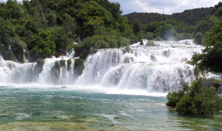 Cascada rodeada de espeso bosque cerca de Krk, Primorje-Gorski Kotar, Croacia, bajo un cielo brillante.