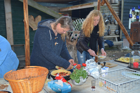 Twee vrouwen bereiden buiten eten aan een tafel met verse ingrediënten bij Feather Down Hohenwarter Seehof.