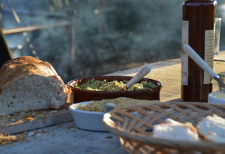 Brød, dip og olie på rustikt bord ved Feather Down Hohenwarter Seehof feriepark i Thüringen, Tyskland.