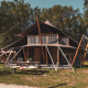 Safari teltet Kings Lodge + Hot Tub ved Sandberghe i Holland, omgivet af træer og grønt område.
