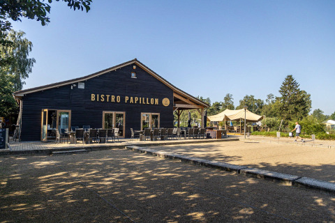 Foto esterna del Bistro Papillon presso Camping Papillon, villaggio vacanze in Limburgo, Belgio, con tavoli.
