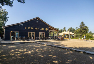 Foto esterna del Bistro Papillon presso Camping Papillon, villaggio vacanze in Limburgo, Belgio, con tavoli.
