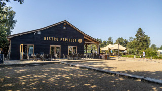 Foto exterior de Bistro Papillon en Camping Papillon, parque vacacional en Limburg, Bélgica, con terraza.