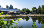 Spiaggia tranquilla sul lago con lettini, ombrelloni e pannelli solari vicino a Kinrooi, Limburgo, Belgio.