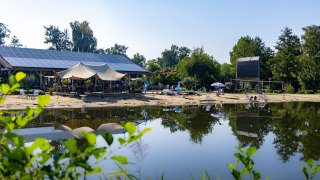 Rustig meerstrand met ligstoelen, zonneluifels en zonnepanelen in de buurt van Kinrooi, Limburg, België.