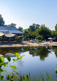 Una playa tranquila junto al lago con tumbonas y paneles solares cerca de Kinrooi, Limburg, Bélgica.