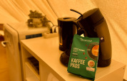 Macchina del caffè, cialde e bollitore su scaffale in tenda tipi al Camp Kyllburg, Germania.